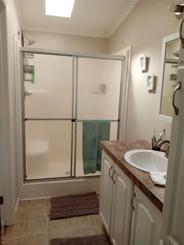 a bathroom with a granite countertop sink a mirror and a shower