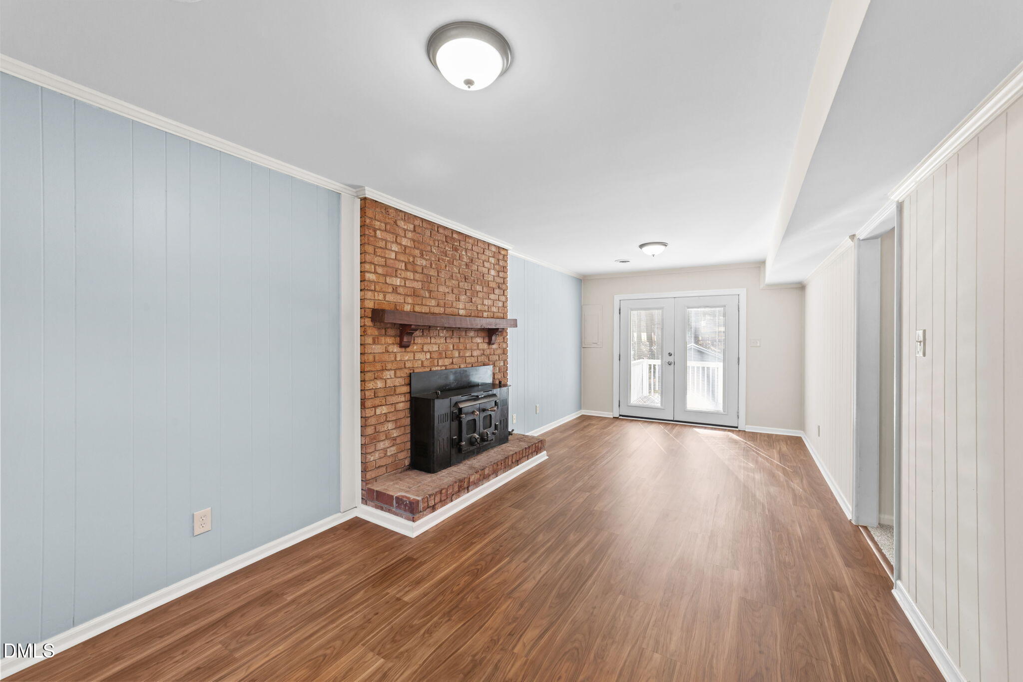 205 November Street Garner, NC 27529 - Photo 13 of 26 an empty room with wooden floor fireplace and windows