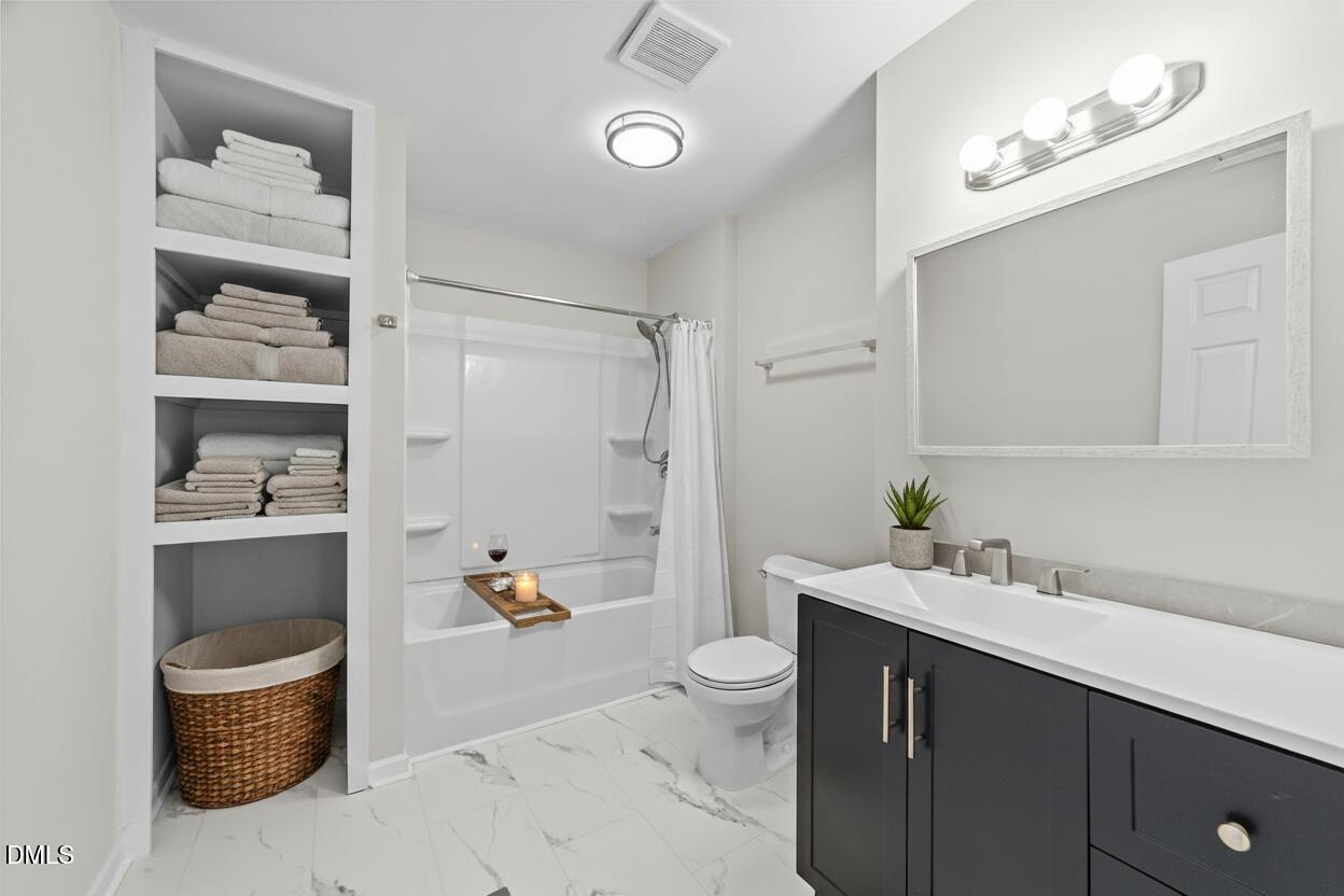 205 November Street Garner, NC 27529 - Photo 22 of 26 a spacious bathroom with a granite countertop sink a toilet and shower