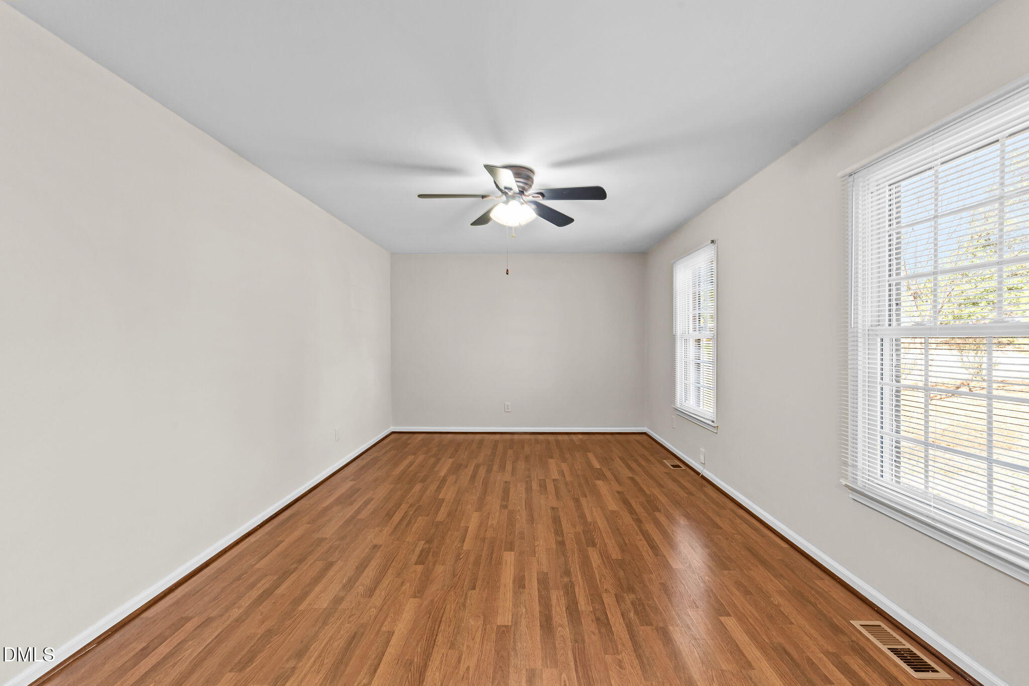 205 November Street Garner, NC 27529 - Photo 7 of 26 an empty room with wooden floor and windows
