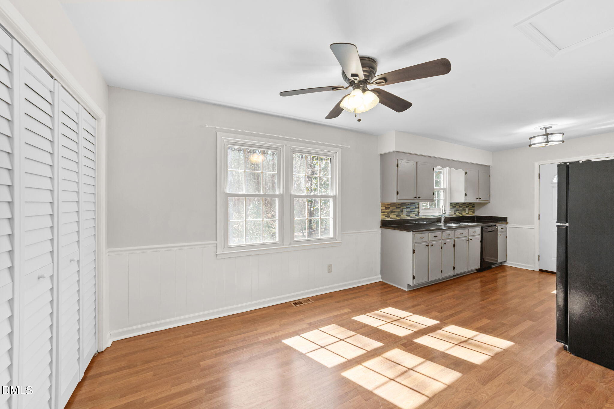 205 November Street Garner, NC 27529 - Photo 10 of 26 a kitchen with stainless steel appliances kitchen island granite countertop a refrigerator a sink dishwasher and white cabinets with wooden floor
