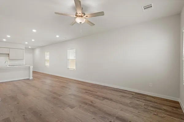 a view of an empty room with a kitchen