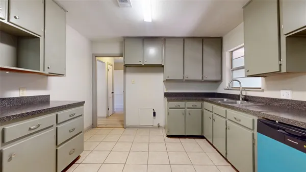 a kitchen with a sink dishwasher stove and cabinets