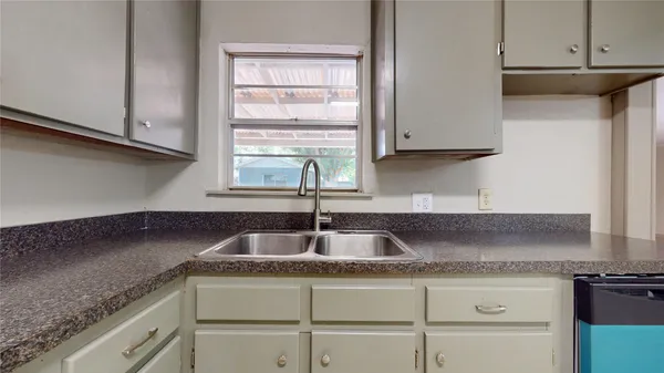 a kitchen with granite countertop a sink and a stove