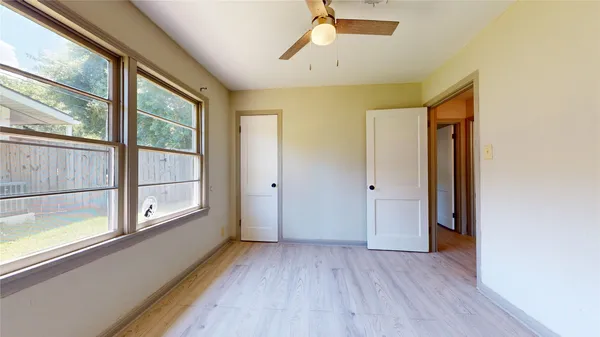 a view of a hallway with wooden floor and a window
