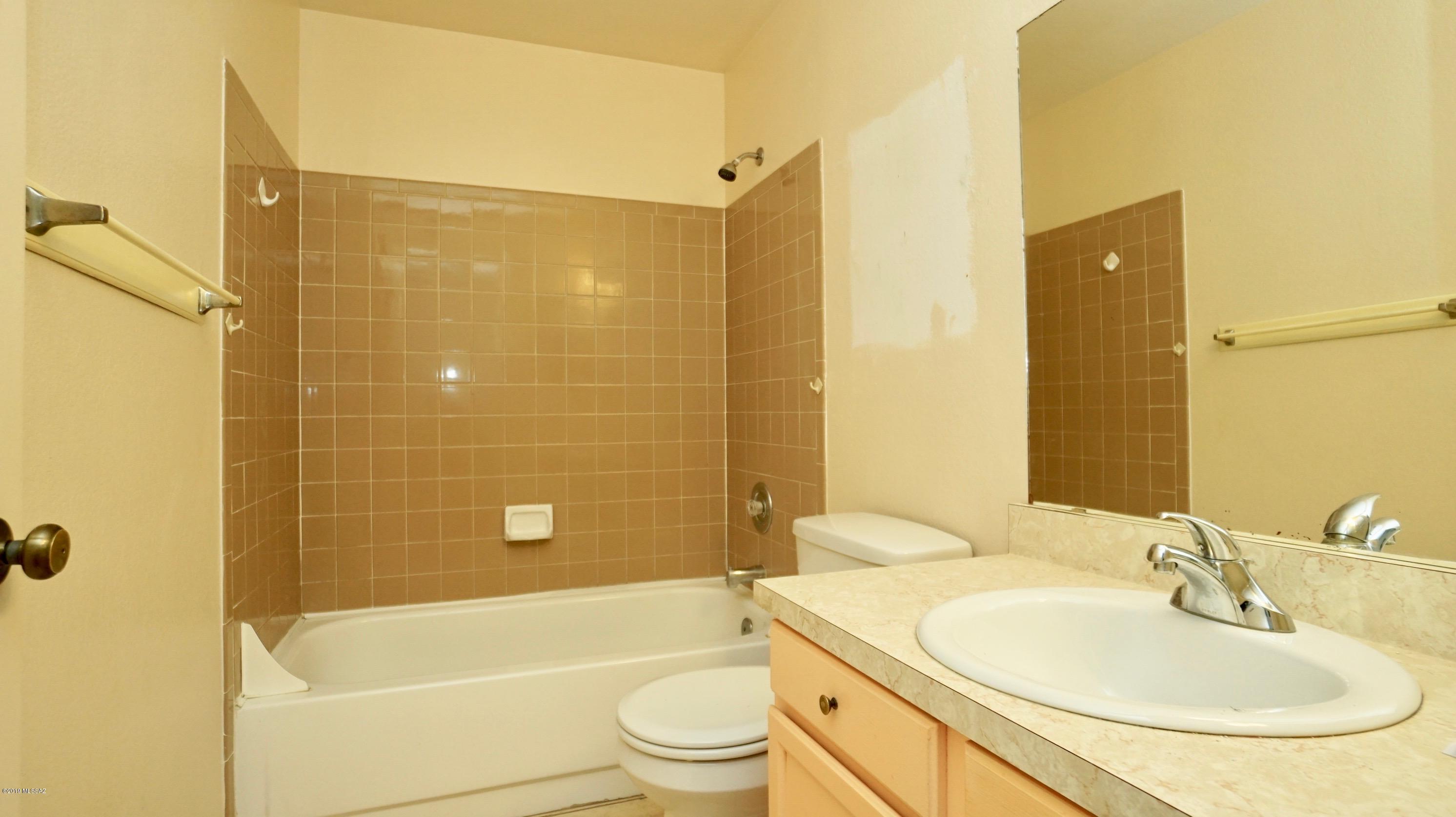 4796 South Lincoln Ridge Drive Tucson, AZ 85730 - Photo 9 of 12 a bathroom with a sink a toilet and shower