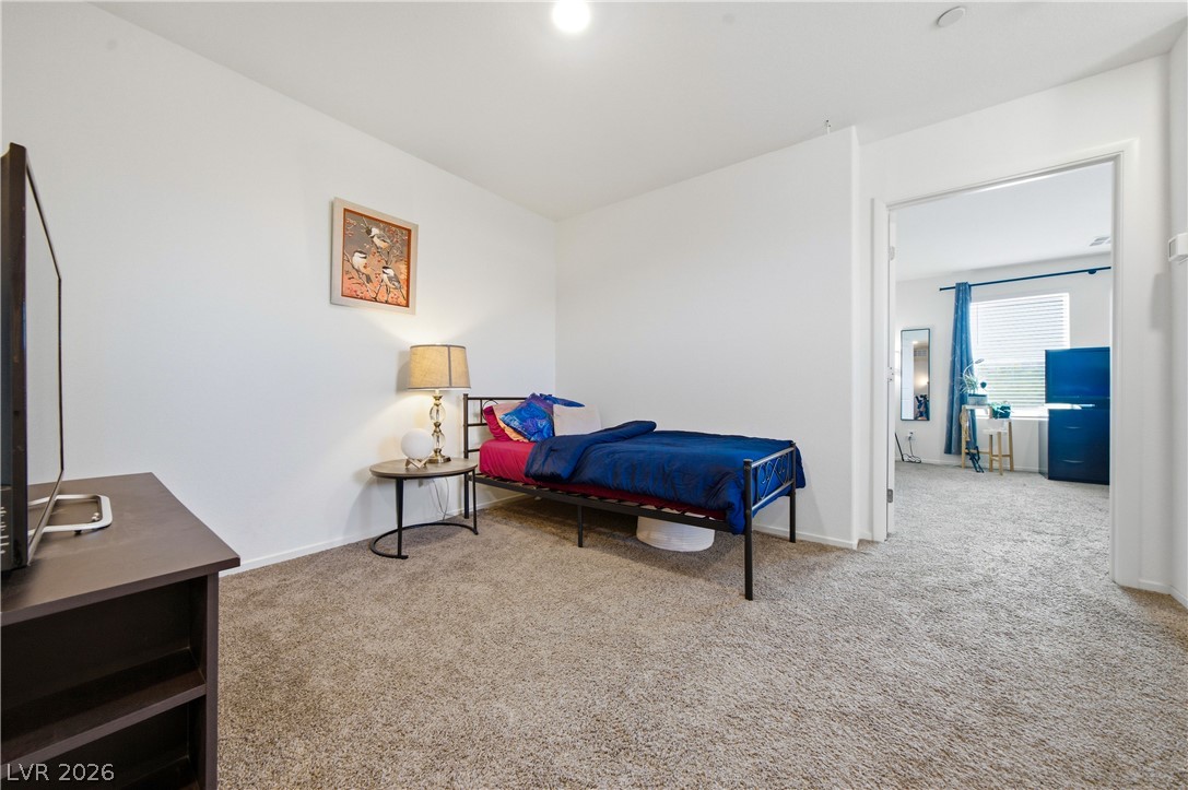 495 Blue Ridge Cove Henderson, NV 89002 - Photo 21 of 32 A well-lit bedroom features plush carpeting and convenient access to an adjoining space.