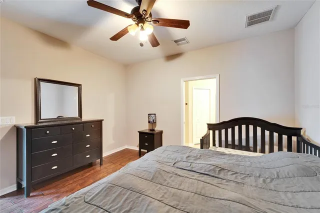 a bedroom with a bed a chandelier and a dresser
