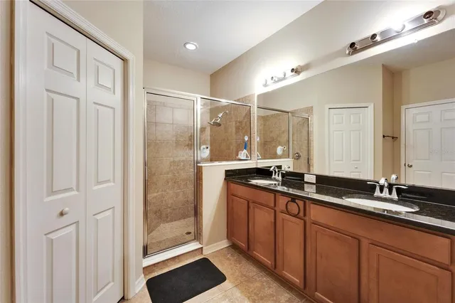 a bathroom with a granite countertop sink a mirror and a shower