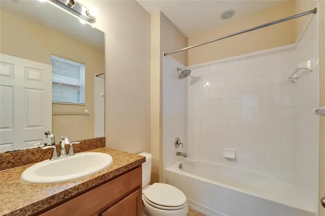 a bathroom with a granite countertop sink toilet mirror and shower