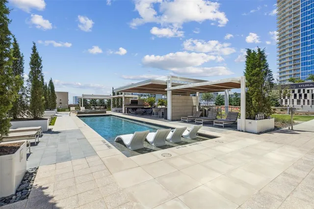a view of a swimming pool with sitting area and furniture