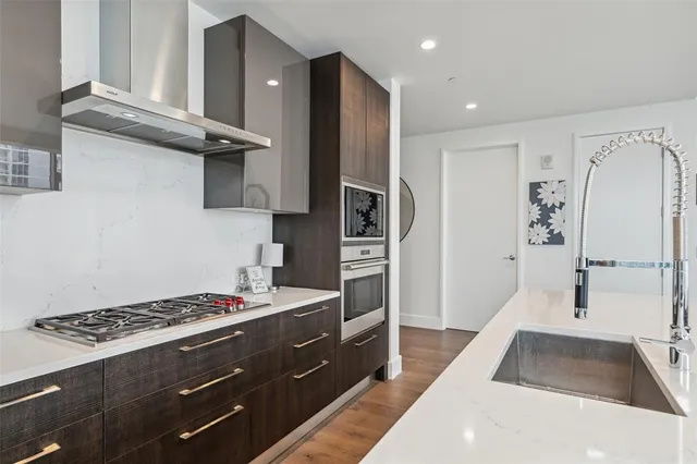 a kitchen with stainless steel appliances granite countertop a refrigerator and a stove top oven