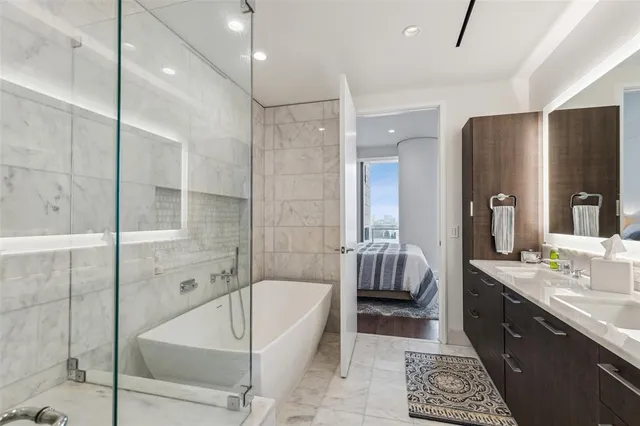 a spacious bathroom with a tub sink and glass door shower