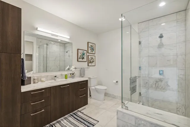 a spacious bathroom with a shower sink mirror and toilet