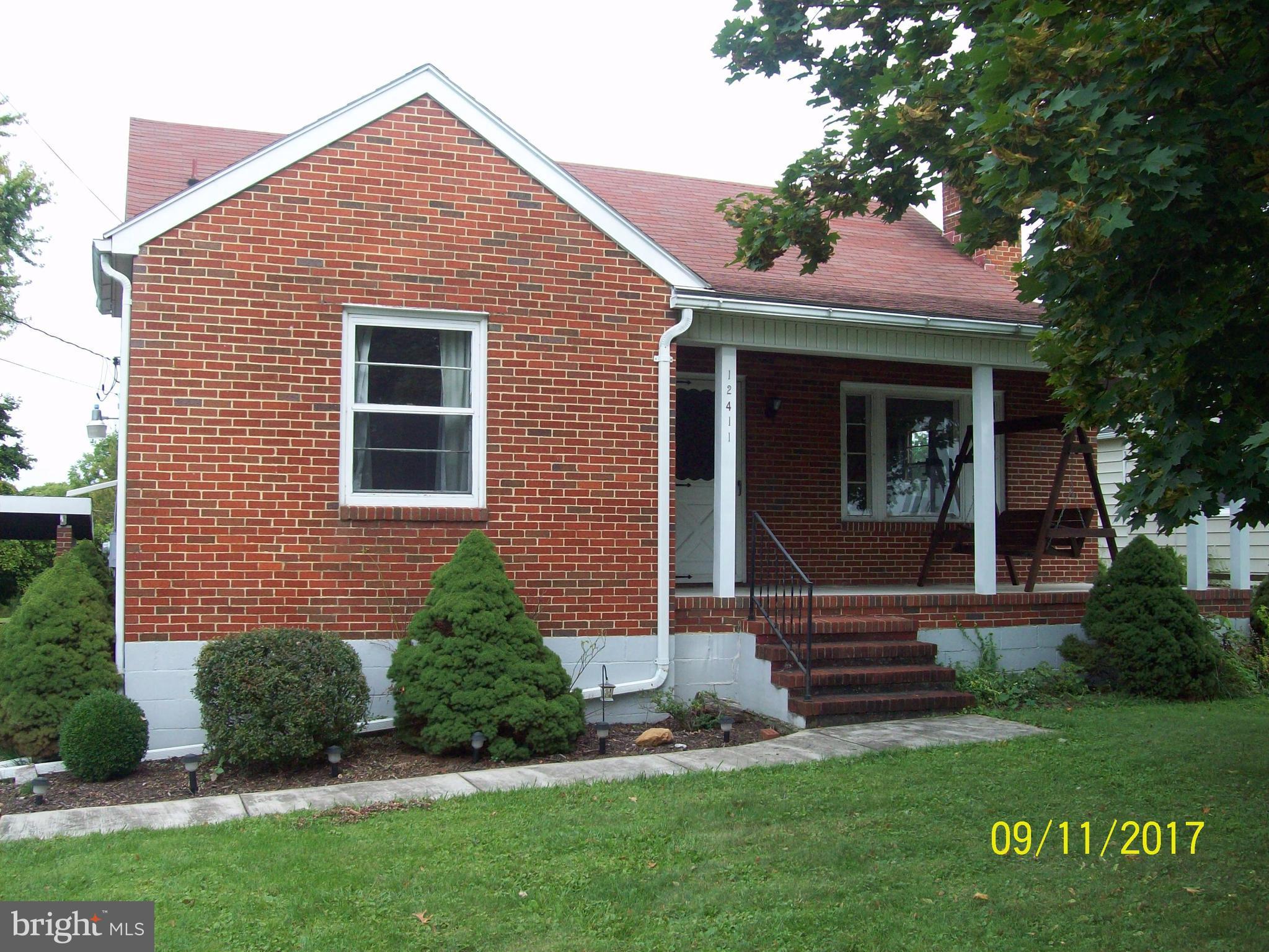 12411 Big Spring Road Clear Spring, MD 21722 - Photo 1 of 17 a front view of a house with a garden
