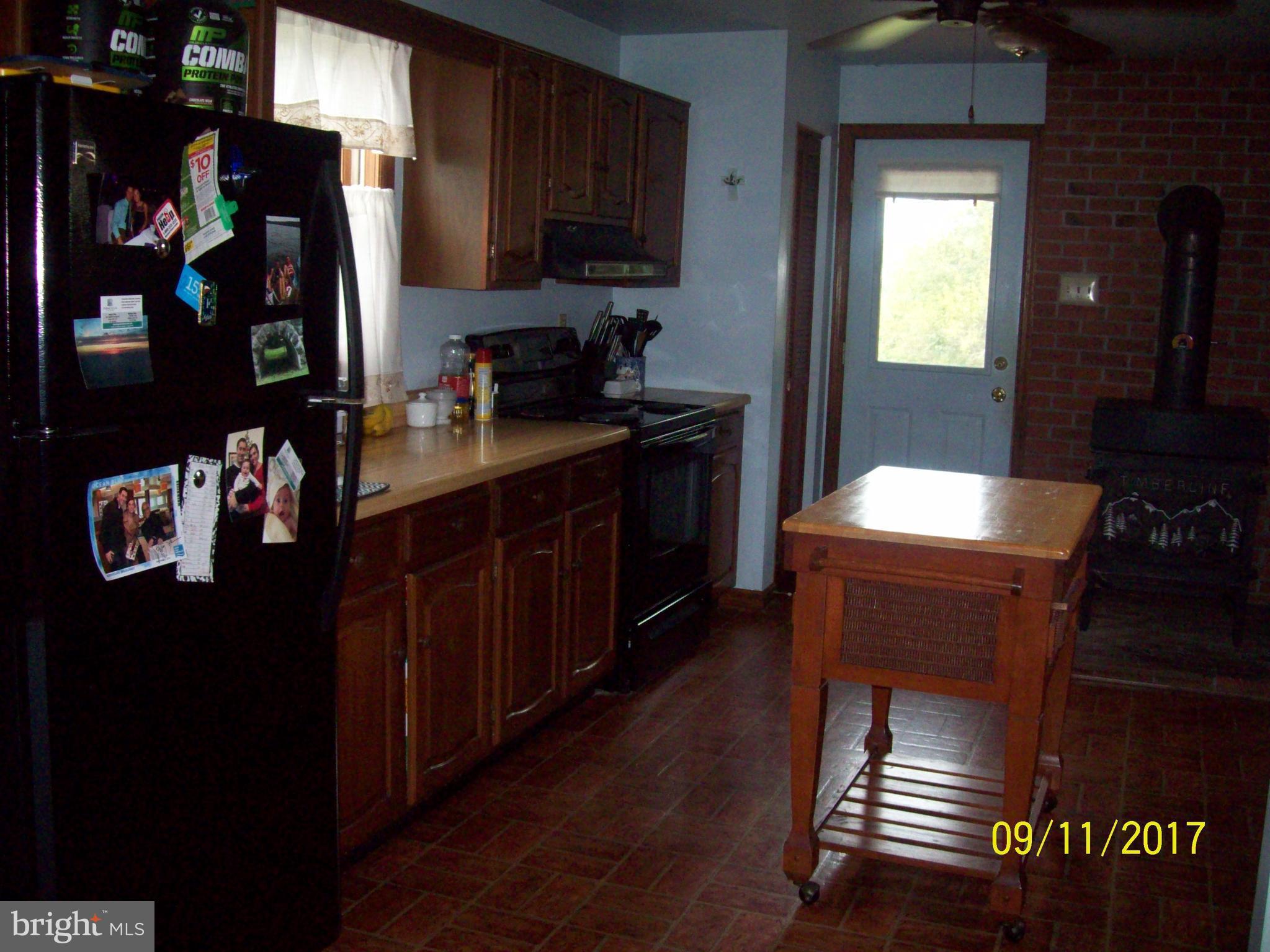 12411 Big Spring Road Clear Spring, MD 21722 - Photo 11 of 17 a kitchen with a refrigerator and a stove