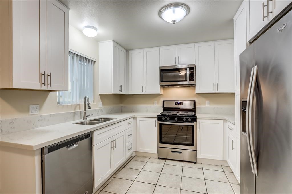 1219 Mitchell Street, Unit D Oceanside, CA 92054 - Photo 2 of 13 a kitchen with stainless steel appliances granite countertop a stove a refrigerator and a sink