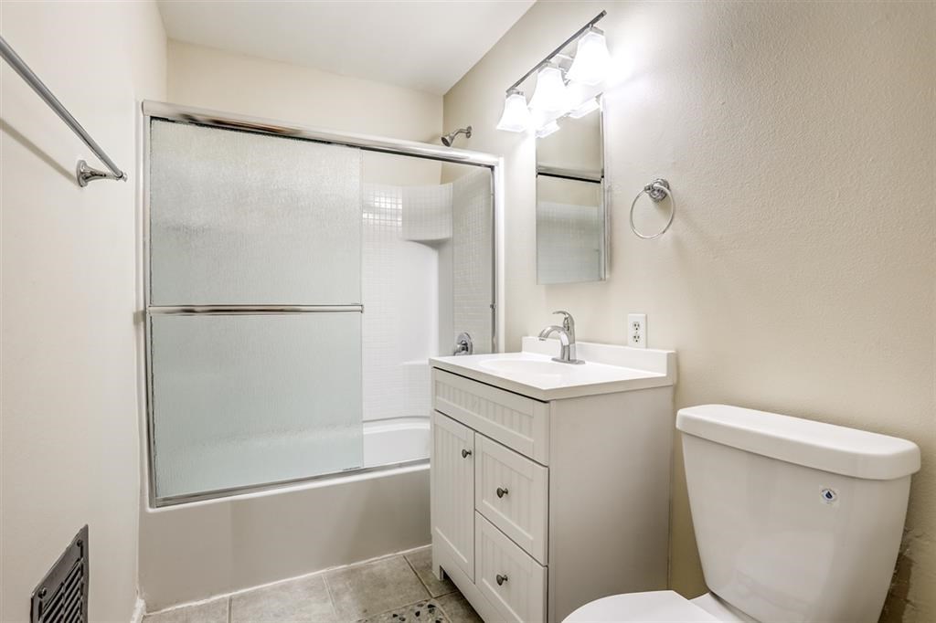 1219 Mitchell Street, Unit D Oceanside, CA 92054 - Photo 9 of 13 a bathroom with a granite countertop sink toilet and shower