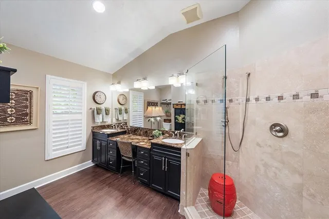 a kitchen with stainless steel appliances granite countertop a stove a sink dishwasher and a refrigerator with wooden floor