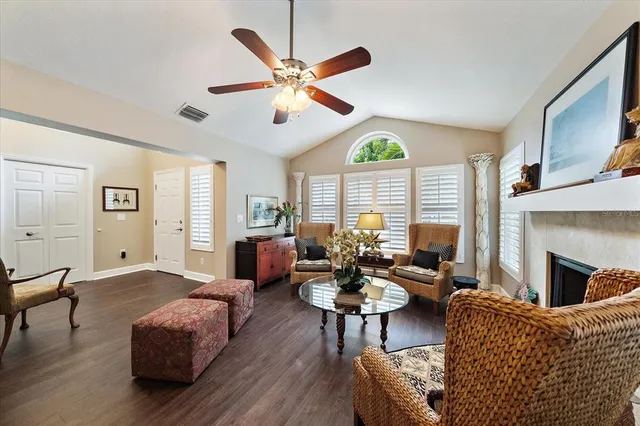 a living room with furniture a fireplace and a large window