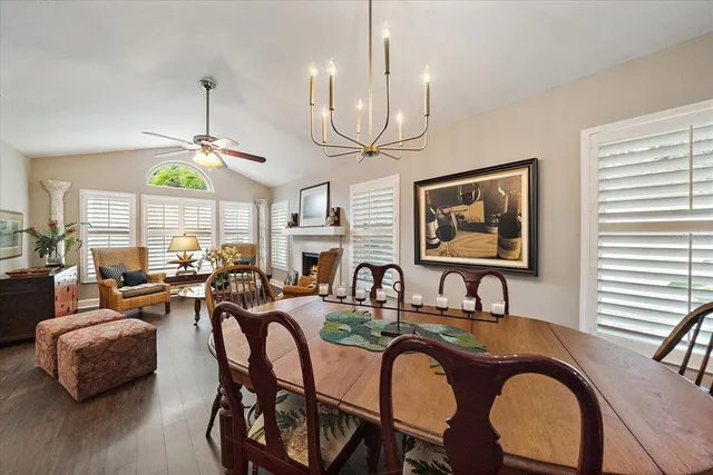 a very nice looking kitchen with granite countertop a stove a sink a dining table and chairs with wooden floor