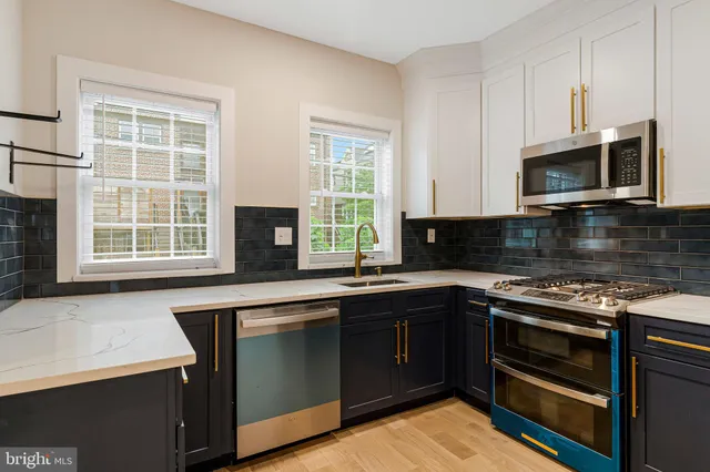 a view of a kitchen with a refrigerator and wooden floor