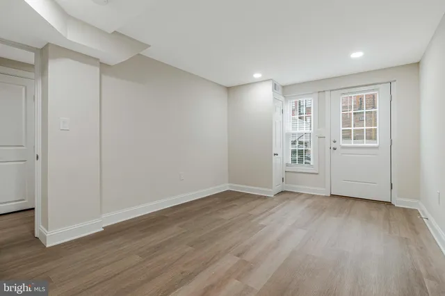 an empty room with wooden floor and white walls