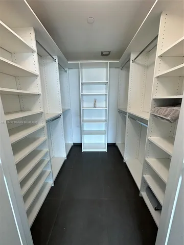 a view of walk in closet with empty racks