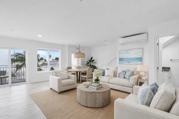 a living room with furniture a rug potted plant and a large window