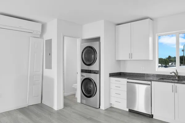a kitchen with granite countertop white cabinets and stainless steel appliances