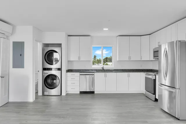 a large kitchen with stainless steel appliances granite countertop a stove a sink and a refrigerator