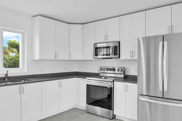 a kitchen with white cabinets and washer