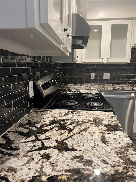 3121 Rosedale Avenue University Park, TX 75205 - Photo 2 of 16 Planned Kitchen featuring white cabinetry, black subway tile backsplash, patterned stone countertops, and a black electric range with a stainless steel range hood. These photos are of a different updated unit in the complex. The planned updates will be similar for this unit.