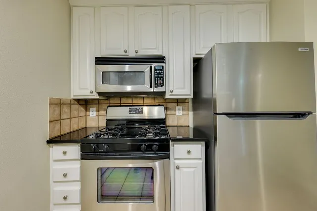 a kitchen with kitchen island a sink stainless steel appliances and a counter top space