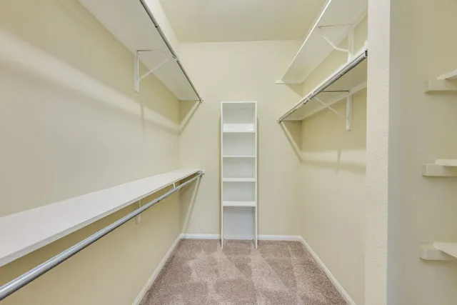 an empty room with a window and a chandelier fan