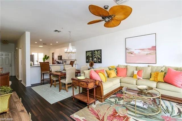 a living room with furniture kitchen view and a chandelier