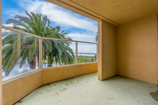 a view of a room with a large window and plants