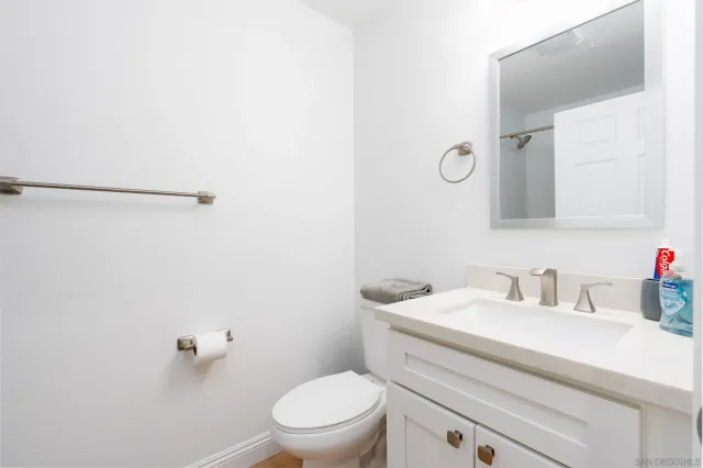 a bathroom with a toilet a sink a vanity and mirror