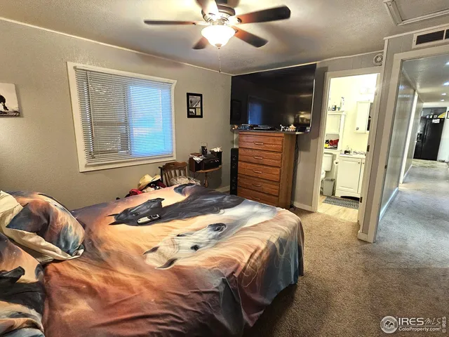 a bedroom with a bed and dresser with mirror