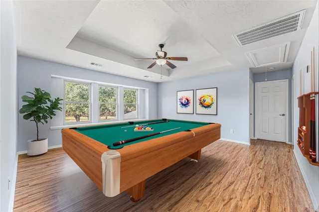 a room with pool table and windows