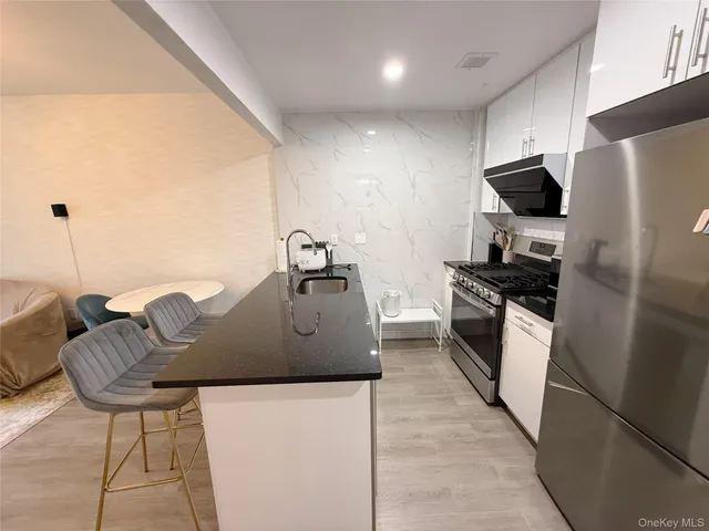 a kitchen with stainless steel appliances granite countertop a sink a refrigerator and a stove