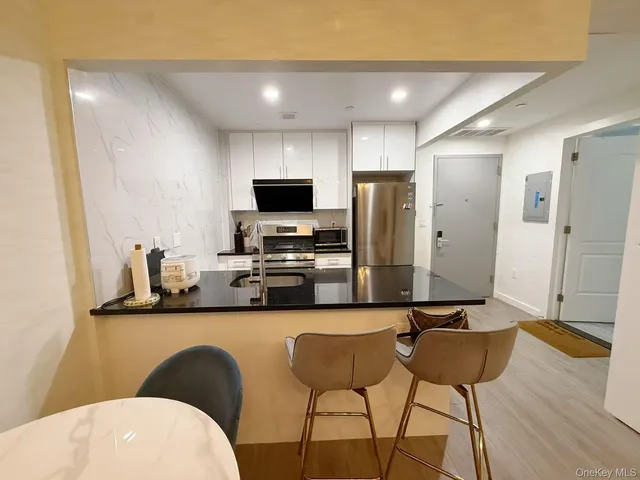 a kitchen with a dining table chairs and a refrigerator