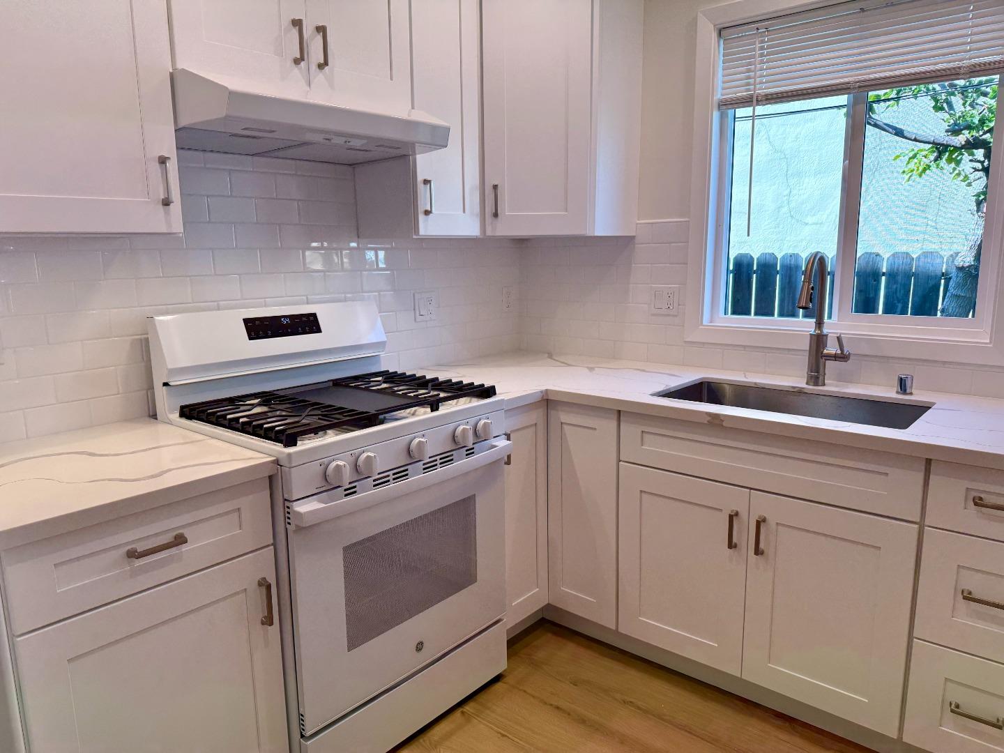 634 Fulton Street Redwood City, CA 94061 - Photo 11 of 24 a kitchen with cabinets appliances a sink and a window