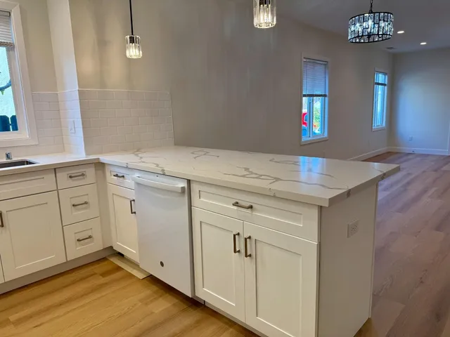 a view of a kitchen with cabinets and wooden floor