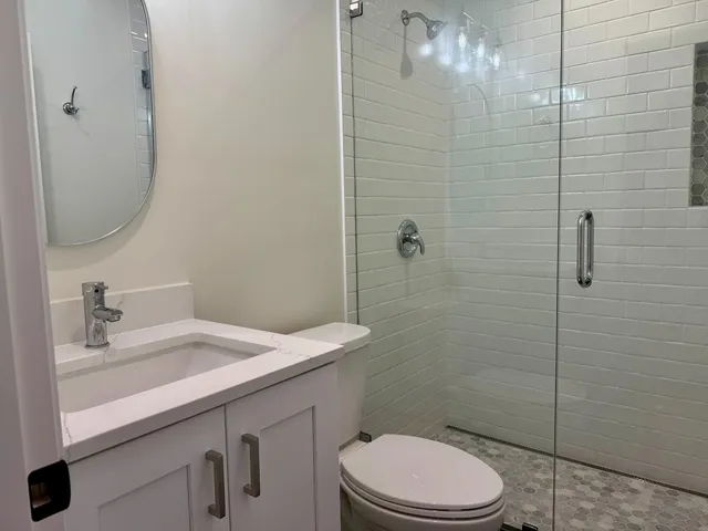 a bathroom with a sink a toilet and shower