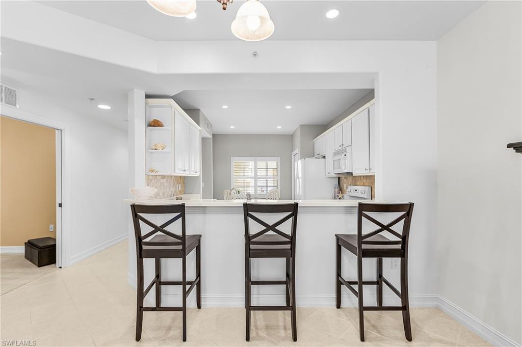 9113 Michael Circle, Unit 7 Naples, FL 34113 - Photo 11 of 34 a view of a dining room with furniture and wooden floor