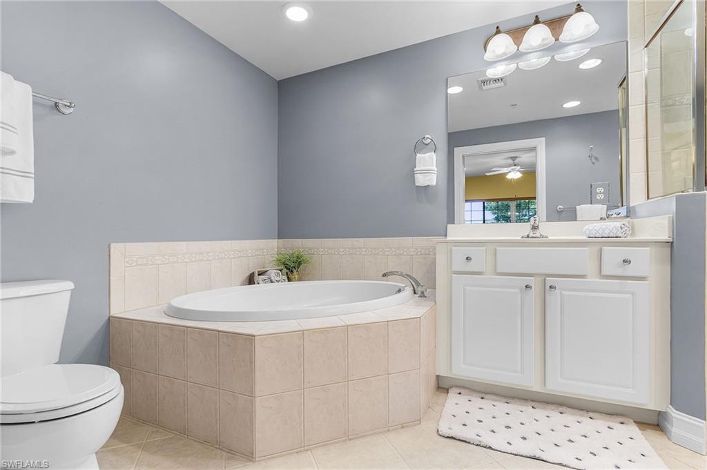 9113 Michael Circle, Unit 7 Naples, FL 34113 - Photo 22 of 34 a bathroom with a sink a toilet and a mirror