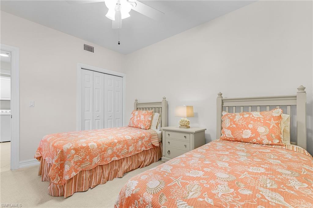 9113 Michael Circle, Unit 7 Naples, FL 34113 - Photo 24 of 34 a bedroom with two beds and a chandelier