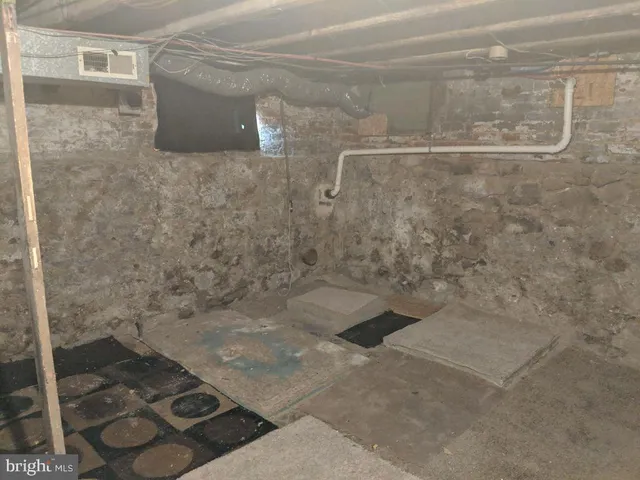 a view of a house with a bench and wooden fence