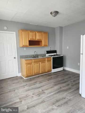 a view of a kitchen with wooden floor and electronic appliances